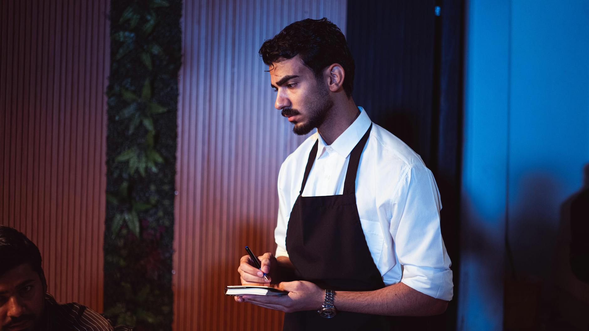 Restaurant manager reviewing a pest-management service log on a clipboard before a Marion County health department inspection